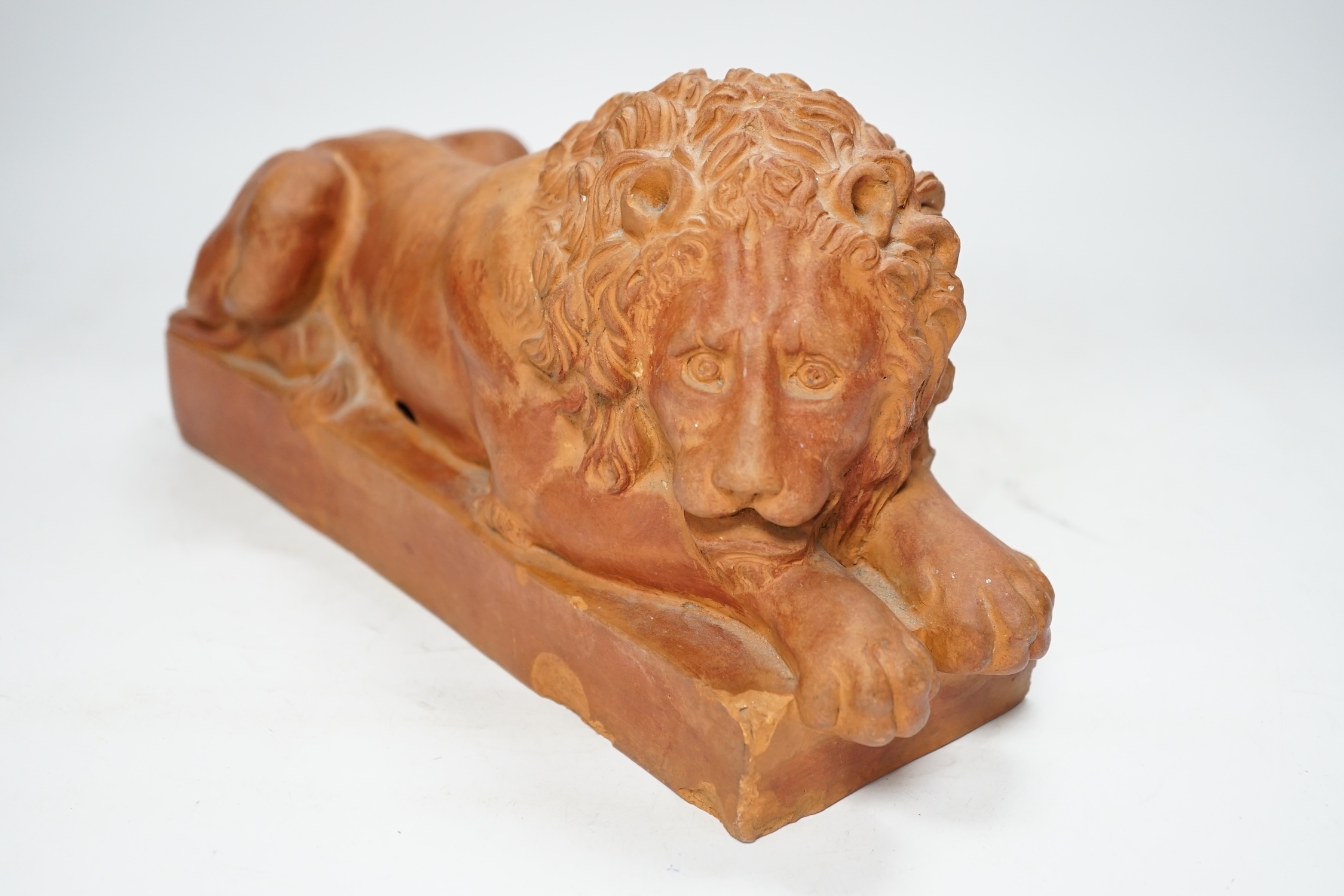 After Antonio Canova (1757-1822), a terracotta figure of a recumbent lion, 33cm. Condition - poor to fair